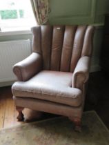 A 20th century leather part wing back chair raised over cabriole legs.