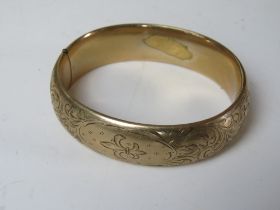 A 9ct gold plated hinged bangle having engraved fleur de lis pattern. Approx 6 x 5.