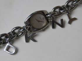 A ladies DKNY stainless steel charm bracelet style wrist watch numbered NY9062