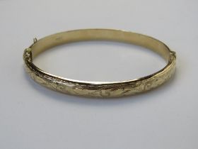 A 9ct gold bangle having floral engraving to front, hallmarked 375, approx 5.