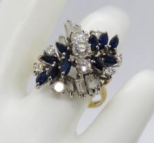 A modern sapphire and diamond cluster ring comprised of three central brilliant cut diamonds in a