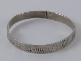 A hallamrked silver bangle having overlapping oval pattern upon, London Jubilee hallmark upon, 5.