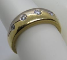 An 18ct white and yellow gold ring set with five round cut brilliant diamonds in rub over settings,