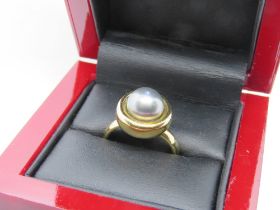 A hallmarked 18ct gold and blue pearl ring, 8mm dia pearl, 8.6g. In light up box.