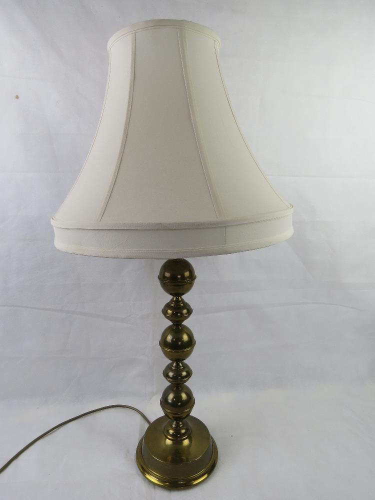 A brass table lamp complete with shade, all standing 79cm high.