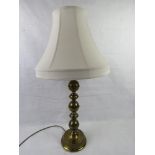 A brass table lamp complete with shade, all standing 79cm high.