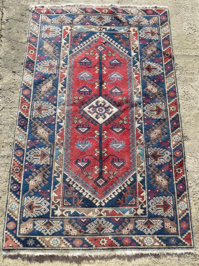 A red and blue ground geometric pattern Oriental rug measuring approx 120 x x195cm.