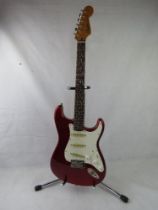 A Fender Squier Stratocaster guitar in red, stand not included.