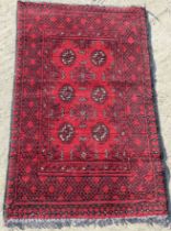 A red ground geometric pattern Oriental rug measuring approx 72 x 110cm.