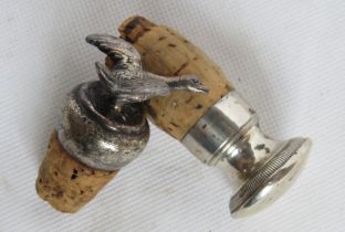 Two silver plated bottle stoppers with corks, one plain, one having duck upon.