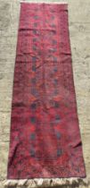 A red ground geometric pattern oriental rug / runner measuring approx 81 x 273cm.