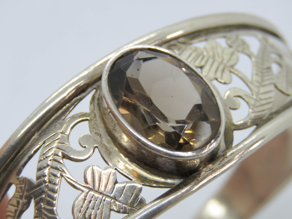 A pierced and engraved silver bangle having large smoky quarts oval cut stone to centre, - Image 3 of 3