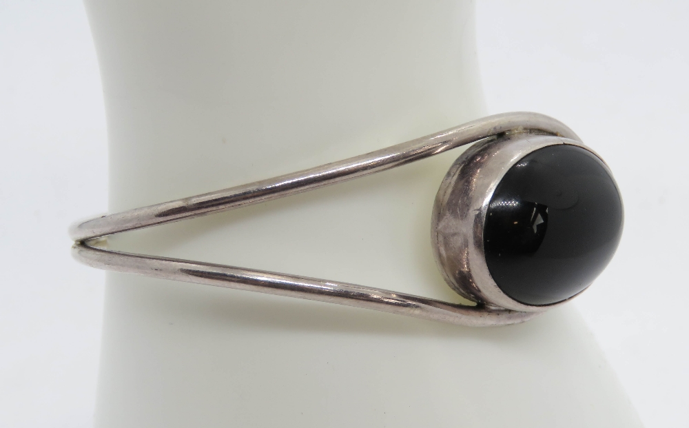 A silver and black onyx cabachon bangle, stamped 925. - Image 2 of 4