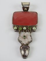 A large silver pendant having floral mother of pearl, green coloured pearl and faceted stones upon,