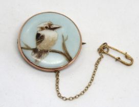 An Australian Kookaburra brooch, the bird on ceramic tile set in rose metal, no apparent hallmark,