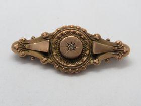 A 9ct rose gold mourning brooch having diamond in star setting to front and glazed locket to back,