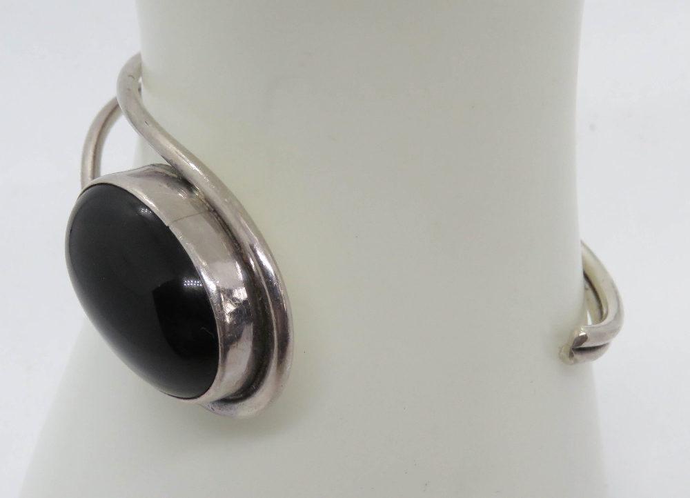 A silver and black onyx cabachon bangle, stamped 925. - Image 4 of 4