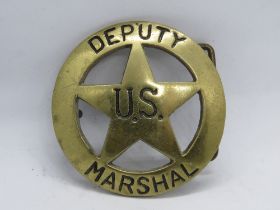 A brass 'Deputy US Marshal' belt buckle, numbered 606 to back.