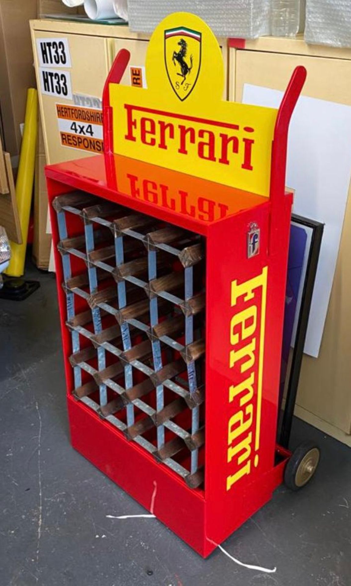 A superb automotive wine rack in Ferrari colours formed from an original Castrol Oil mobile rack.