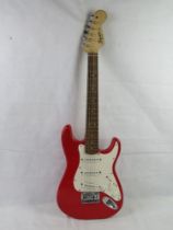 A Fender Squier Mini electric guitar in red.