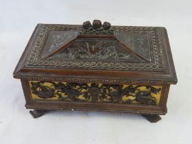 A delightful black forest type carved wooden jewellery box opening to reveal green velvet lined