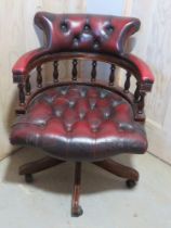 A red Chesterfield type studded office 'captains' chair on castors.