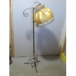 A wrought iron floor standing lamp with silk shade.