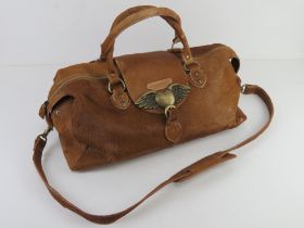 A cow hide handbag by Louise Hempleman having winged heart decoration to clasp, approx 44cm wide.