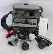 An Olympus camera in bag with lens, flash and other accessories.