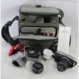 An Olympus camera in bag with lens, flash and other accessories.