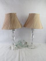 A pair of contemporary glass table lamps with pink silk shades.