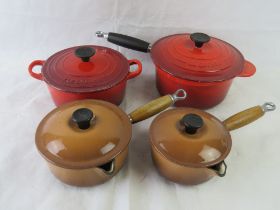 Four Le Creuset pans with lids.