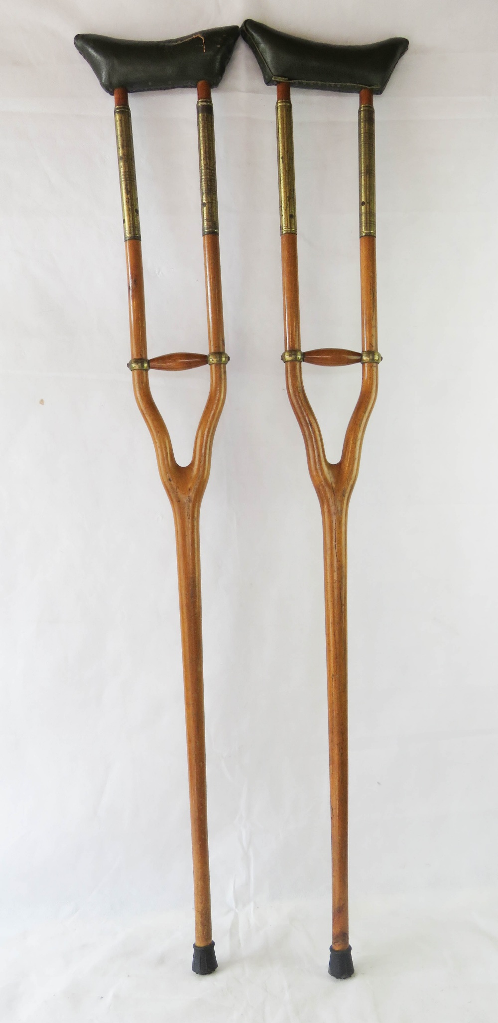 A pair of vintage brass mounted crutches, with sprung leather supports.