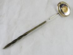 A punch ladle with inset coin from 1791.