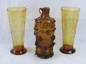 A hand blown brown glass jug together with a pair of amber glass etched glasses.