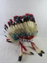 A Native American beadwork and feather shroud headdress.