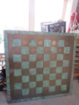 A large fold over chess tabletop, brass covered with horses head design upon, 1m x 1m open.