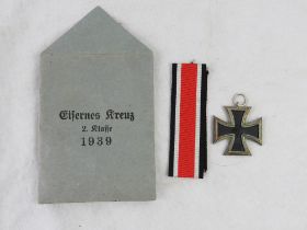 A WWII German Iron Cross 2nd Class in original 'Eisernes Kreuz' paper packet, with ribbon,