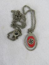 A red enamelled Swastika pendant on chain.