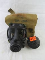 A gas mask with filter in canvas bag.