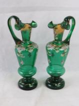 A pair of late 19th century gilded and painted green small jugs, each standing 23cm high.