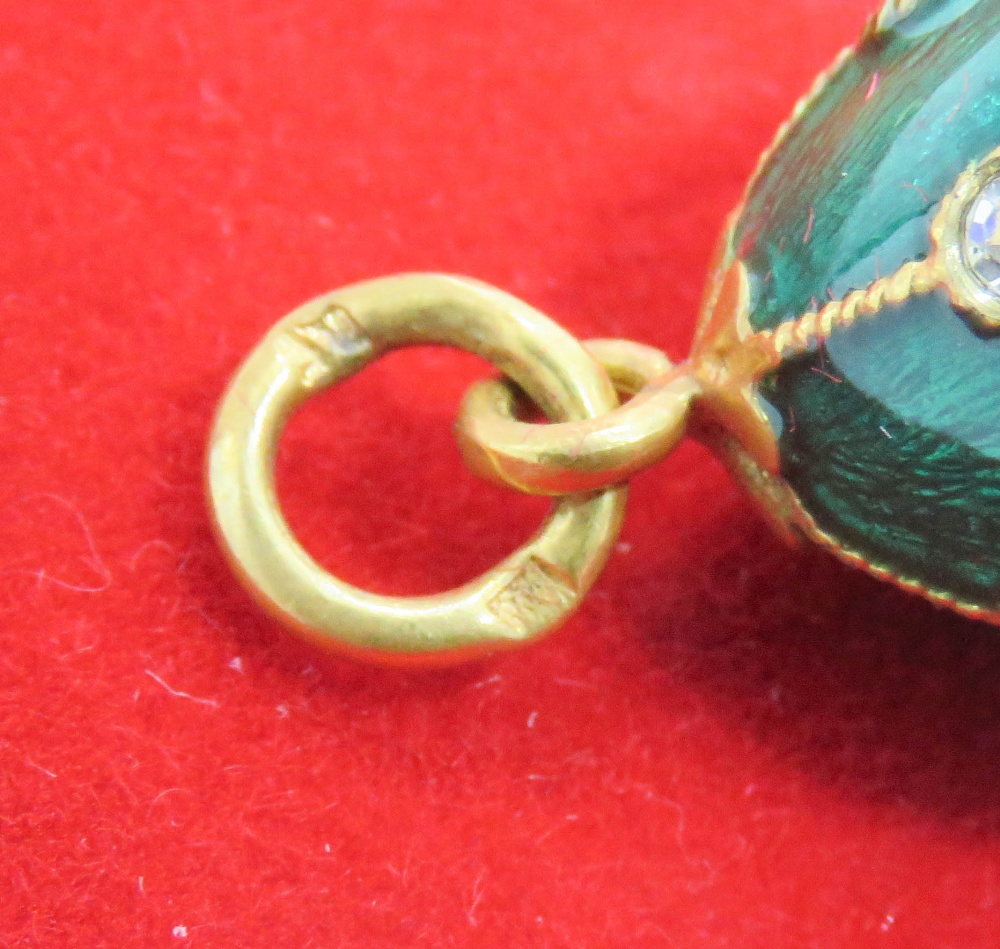 A 'Faberge' type egg charm having green enamel, white and blue stone decoration upon. - Image 2 of 3