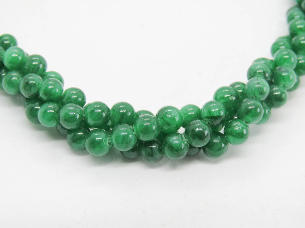 A three strand woven jade bead necklace with chrome clasp, 46cm. - Image 2 of 2