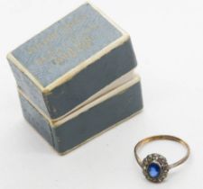 An antique gold and silver ring having central oval blue paste surrounded by white stones,