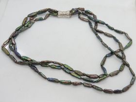 A silver and flat pearl three strand necklace.