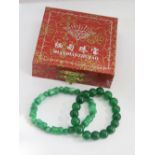 Two green jade elasticated bracelets.