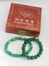 Two green jade elasticated bracelets.