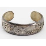 A heavy Sterling silver bangle with Arabic style decoration upon, 44.2g.