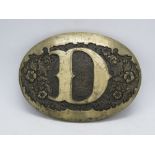 An Award Design Medals Inc belt buckle with D design upon.