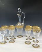 A SET OF TWELVE ST LOUIS CRYSTAL WINE GLASSES, A CLARET JUG AND STOPPER, EACH GILT WITH VINE BANDS